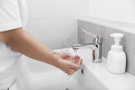妇女用肥皂和洗手在开水龙头下清洗科罗纳图片