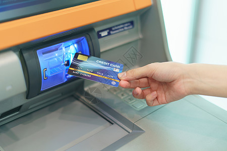 女性用手插入信用卡 放入银行机器中与Woddr图片