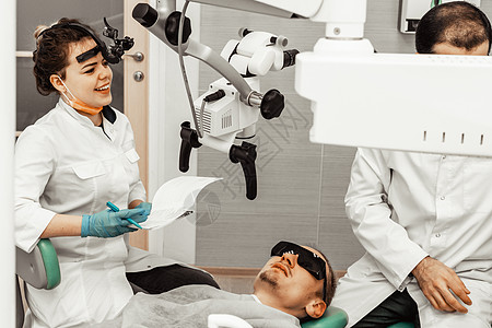两个牙医治疗一个病人 牙医的专业制服和设备 医疗保健装备医生工作场所 牙科女士牙齿访问药品医学微笑口腔科卫生员假牙工具图片