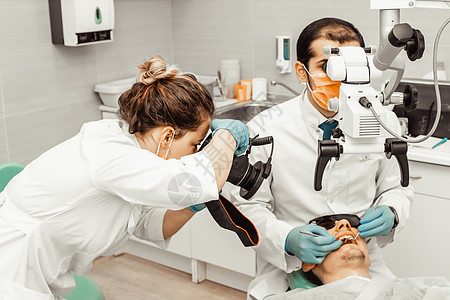 两个牙医治疗一个病人 牙医的专业制服和设备 医疗保健装备医生工作场所 牙科口服访问女士镜子医学衰变口腔科外科卫生牙齿图片