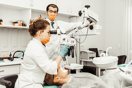 两个牙医治疗一个病人 牙医的专业制服和设备 医疗保健装备医生工作场所 牙科诊所矫正假牙镜子程序医院口腔科卫生微笑女性图片