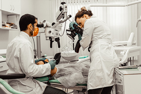 两个牙医治疗一个病人 牙医的专业制服和设备 医疗保健装备医生工作场所 牙科工具牙科技师女士卫生员牙疼程序口腔科诊所口服治愈图片
