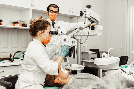 两个牙医治疗一个病人 牙医的专业制服和设备 医疗保健装备医生工作场所 牙科程序女性镜子牙疼卫生工具治愈医学诊所女士图片