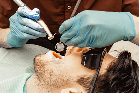 手术时坐在牙医椅上的病人 拔牙 植牙 牙医的专业制服和设备 医疗保健装备医生工作场所 牙科医学卫生员假牙微笑女士医院口服镜子程序图片