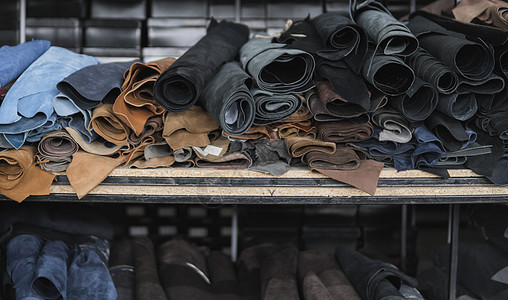 不同的皮革卷 彩色皮革碎片 成卷的天然棕色和黑色等皮革 制造包袋鞋服及配饰的原料生产材料奢华手工制造业工具衣服工厂皮匠动物图片