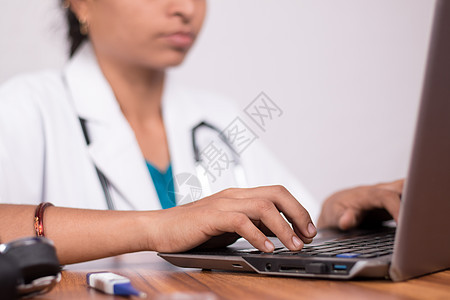 在冠状病毒或 covid-19 大流行期间 忙于在笔记本电脑上工作的医生手的特写镜头-在计算机上与患者进行在线聊天 远程医疗或远图片