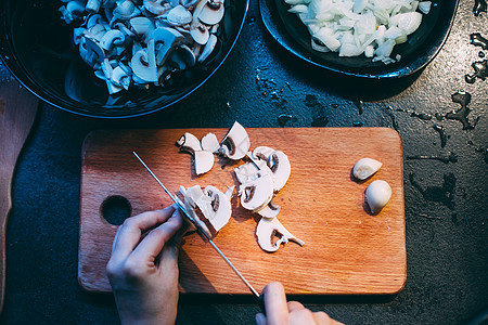 煮饭前切蘑菇 用刀手握手饮食男人桌子盘子食谱蔬菜女士厨房木头食物图片