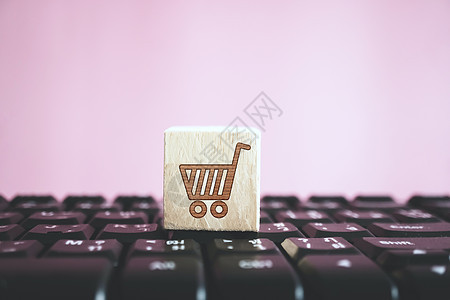 计算机键盘上的木板上特写了购物车图标 在线商店业务技术 掌声消费者零售商品钥匙笔记本木头店铺营销服务立方体图片