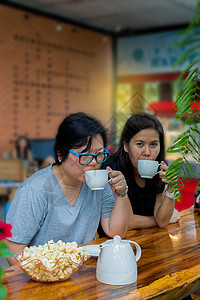 在咖啡店喝酒的亚洲妇女 最好朋友八卦闺蜜女士乐趣餐厅女孩们女性团体杯子爆米花图片