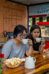 在咖啡店喝酒的亚洲妇女 最好朋友享受快乐女士乐趣食物女性爆米花朋友们杯子女孩们图片