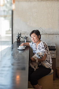 咖啡店咖啡厅中的亚洲妇女和狗女性犬类女士餐厅玻璃宠物幸福朋友哺乳动物木头图片