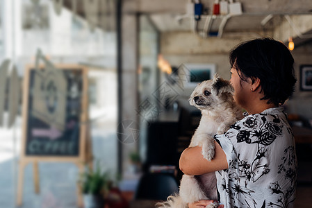 咖啡店咖啡厅的亚洲女人和狗动物椅子幸福女士犬类女孩训练桌子哺乳动物友谊图片