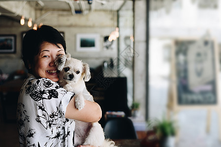 咖啡店咖啡厅的亚洲女人和狗木头小狗贵宾朋友友谊宠物幸福闲暇咖啡桌子图片