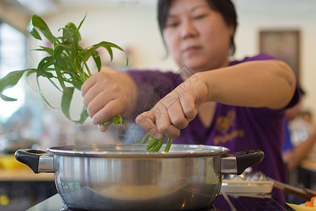 亚洲女人把蔬菜放进热锅里做饭平底锅蒸汽主妇成功女士厨房家庭荣耀检查烹饪图片