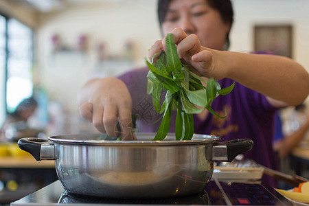 亚洲女人把蔬菜放进热锅里做饭工作妻子女士女性蒸汽烹饪食物成功女孩平底锅图片