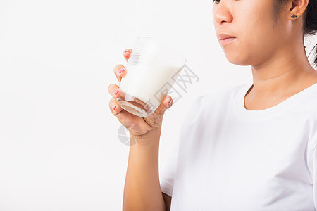 妇女用手握手 喝杯子中的白牛奶微笑早餐饮料营养玻璃女孩奶制品女士饮食成人图片