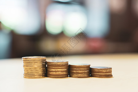 桌上的金币和绿色自然散景背景生长投资桌子套装储蓄商业人士市场金融货币图片