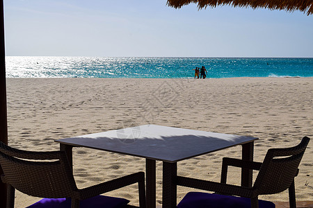 浪漫的 Bucuti  Tara 度假村位于阿鲁巴岛东侧的鹰海滩 棕榈树 白色沙滩伞 几朵云和美丽的白色沙滩令人叹为观止支撑闲暇图片