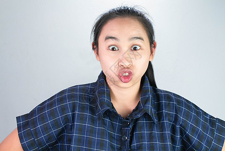 身穿蓝衬衫的亚洲年轻女性 让笑脸让你快乐而不受压力 身体语言和鼓励概念 笑声头发鬼脸表情眼睛情感乐趣女士舌头女孩工作室图片