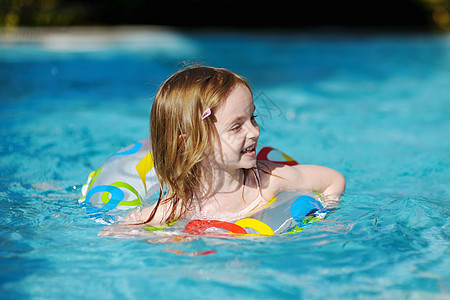 漂亮的小女孩在游泳池游泳幸福活动孩子冒险蓝色乐趣女孩圆圈青年童年图片