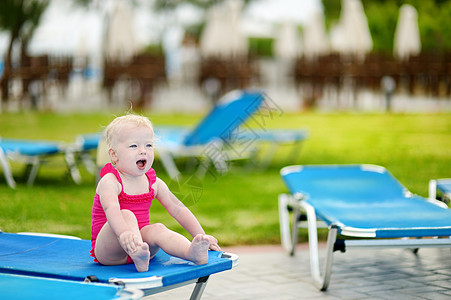 可爱的小孩女孩坐在阳光下游泳衣泳装女孩幸福日光蓝色孩子享受椅子儿童图片