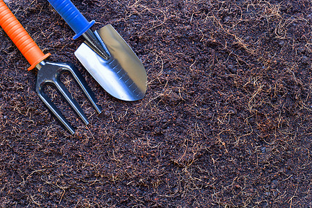 花园铲铁铲和叉在土壤上 用椰子壳的毛发换灰工作宏观金属植物园艺农场盆栽地面绿色白色图片