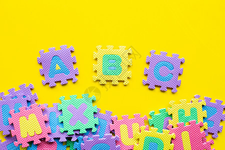 黄色背景上的字母拼图婴儿女孩童年字体立方体教育学校玩具安全孩子们图片