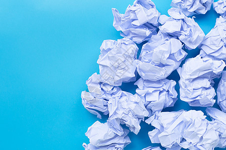 蓝色背景上的白色皱巴巴的纸球办公室想像力技术挫折垃圾回收商业框架床单咖啡图片