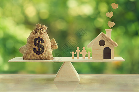 房地产投资和房屋抵押贷款概念 木屋 家庭成员和美元麻袋在木秤上 描述住宅的家庭财务管理图片