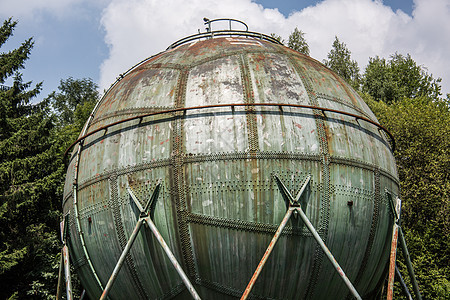 工业纪念碑作为前煤气罐的支撑体上的球柱子气体天空混凝土分支机构蓝色森林乔木容器铆钉图片