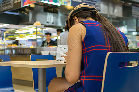 餐厅里用智能手机的女人图片