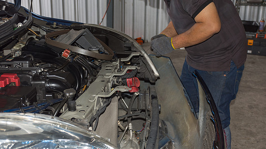 检查停车场的一辆汽车引擎维修劳动服务工作服紧缩修理失败发动机车轮图片