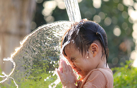 可爱的亚洲小女孩玩得开心 在夏令营里玩水喷水管花园公园孩子们家庭浴缸女孩后院行动微笑洒水器图片
