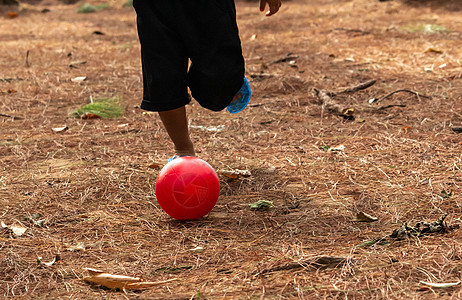 亚洲小孩在公园踢足球的特写腿图片