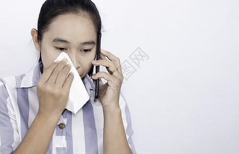 亚洲年轻女性在打电话时有眼睛刺激或眼睛问题 用纸巾擦拭眼泪 在白色背景下被隔离 健康和医疗概念 文本空间图片