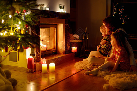 圣诞节在壁炉旁欢乐的家庭姐妹孩子客厅礼物场景房子温暖蜡烛房间庆典图片
