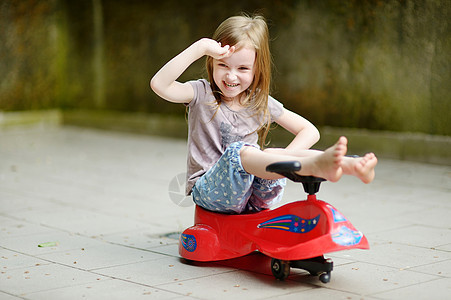 可爱的小女孩驾驶玩具车闲暇司机游戏行动女孩女儿车辆乐趣童年喜悦图片