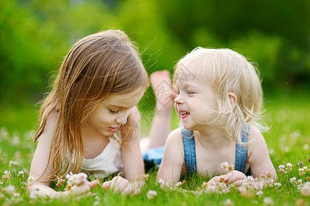 两个可爱的小妹妹 躺在草地上姐姐孩子幼儿园童年乐趣花朵闲暇喜悦女儿女孩图片