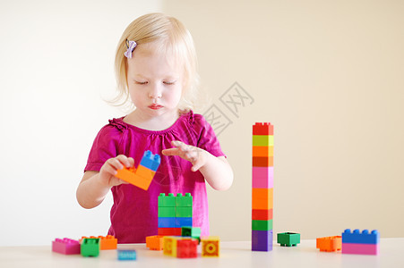 可爱的幼儿女孩玩多彩街区游戏托儿所女孩晴天动物房间快乐家庭学习桌子女性图片