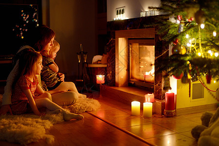 圣诞节在壁炉旁欢乐的家庭房子庆典房间女孩蜡烛奢华礼物场景孩子休息室图片