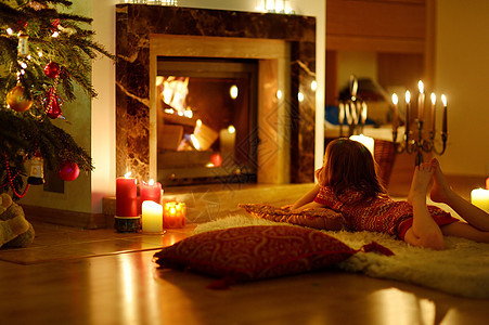 圣诞节在壁炉旁边快乐的小女孩家庭场景奢华温暖女孩蜡烛房子礼物休息室庆典图片