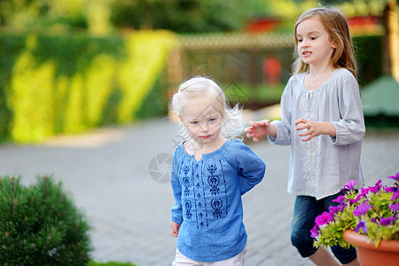 两个小妹妹在暑夏日玩得开心女孩活动团队草地公园乐趣兄弟童年孩子跑步图片