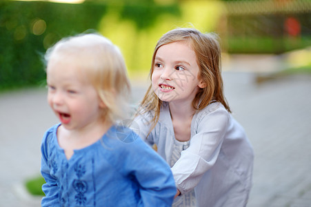 两个小妹妹在暑夏日玩得开心女孩草地喜悦乐趣场地花朵幼儿园闲暇童年女儿图片