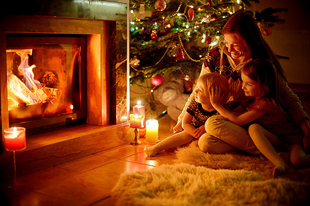 圣诞节在壁炉旁欢乐的家庭礼物场景房间休息室奢华客厅兄弟姐妹成人母亲庆典图片