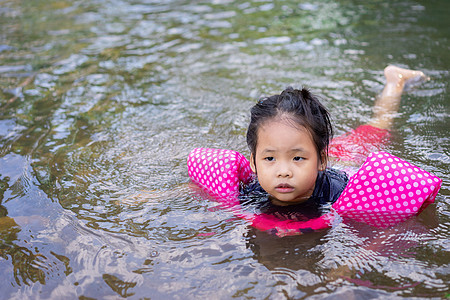 小亚洲女孩在河里游动乐趣公园白色幸福森林假期微笑石头岩石孩子图片