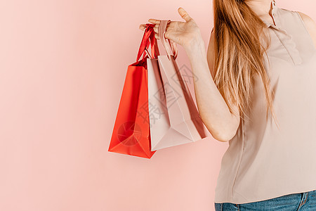 购物和消费 年轻漂亮的女孩带着纸袋购物 粉红色的背景 节日礼物的选择 为自己购物 小样购物狂狂欢闲暇女士购物者客户中心成人快乐零图片