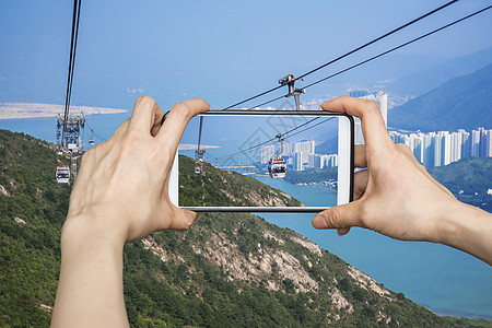 女孩用手机智能手机在有线车上拍照 来自Hon石头女性技术假期快照药片海洋城市阳光悬崖图片
