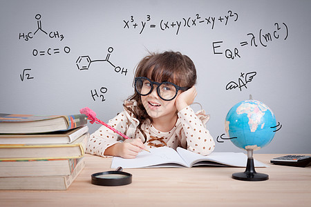 教育概念 学校可爱的小女孩 乐于做家庭作业 数学方程式和化学公式在背景中使用 (笑声)图片