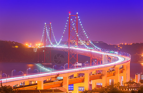 4月25日大桥(Ponte 25 de Abril)的景象与烟雾中的汽车灯光路迹图片