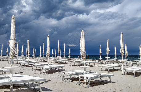 蓝海上有灰色的乌云 还有一小滴旅行沙滩晴天商业天气男人天空海岸椅子遮阳棚图片